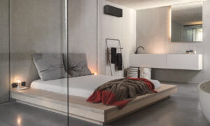 Airconditioning unit in a stylish minimalist bedroom with integrated bath area.