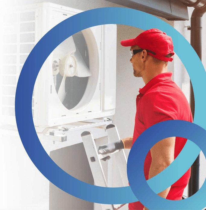 An engineer wearing a red shirt and red cap is installing a heat pump at a home